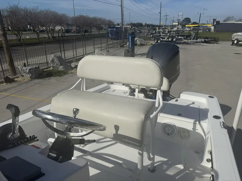 Slide: The Image of 2013 BlackJack 224 boat with steering wheel and seating, parked outdoors. - 10