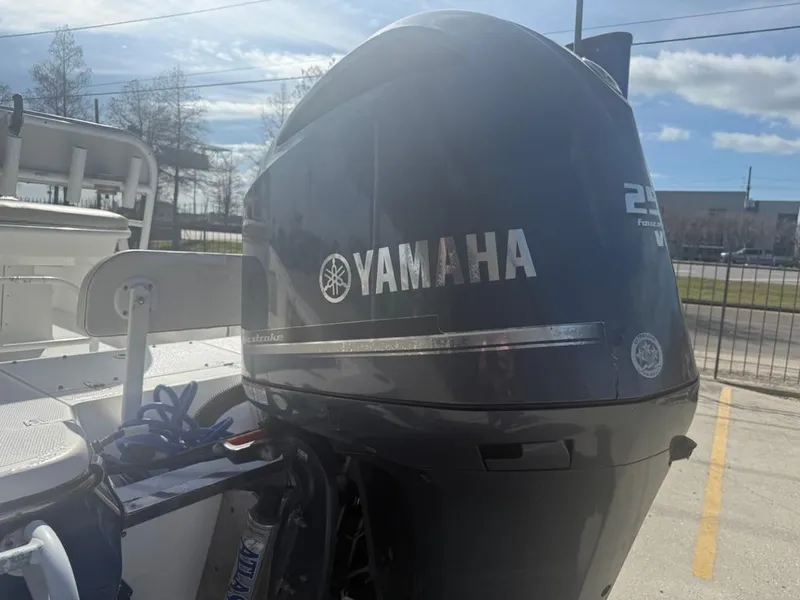 Slide: The Image of Yamaha outboard motor on a 2013 BlackJack 224 boat, parked outdoors. - 12