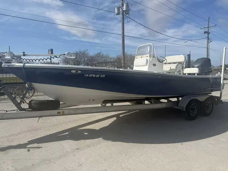 Slide: The Image of 2013 BlackJack 224 boat on trailer, blue and white, parked outdoors. - 4