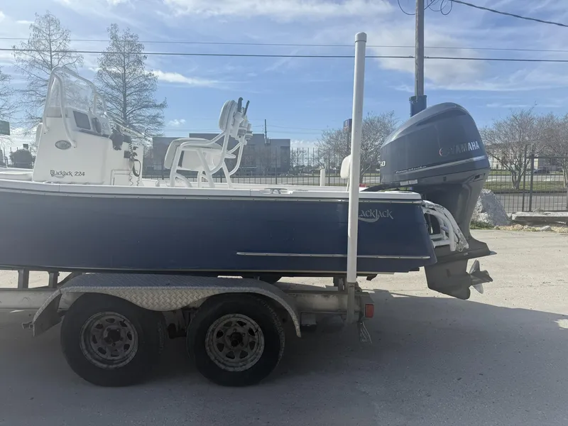 Slide: The Image of 2013 BlackJack 224 boat on trailer with Yamaha outboard motor, parked outdoors. - 9