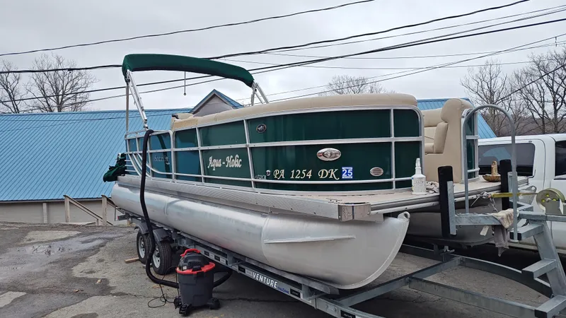 Slide: The Image of 2012 South Bay 722CR pontoon boat on trailer, green exterior, parked outdoors. - 7