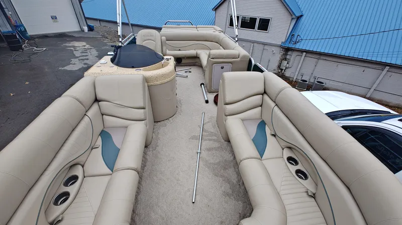 Slide: The Image of Interior of a 2012 South Bay 722CR pontoon boat with beige seating and cup holders. - 8