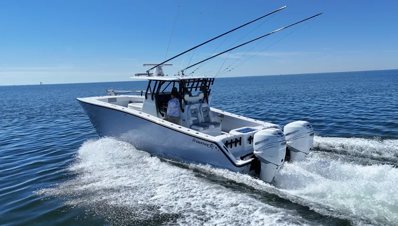 Slide: The Image of 2022 Freeman 34VH boat cruising on open water, featuring dual outboard engines. - 14