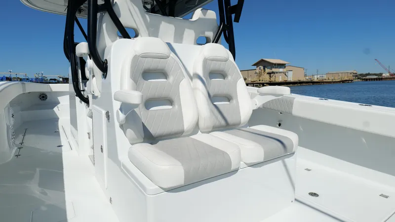 Slide: The Image of 2022 Freeman 34VH boat with white cushioned seats, dockside view. - 38