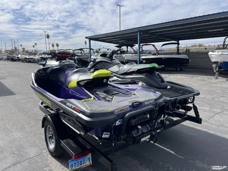 Slide: The Image of 2021 Yamaha WaveRunner GP1800R and Sea Doo RTX300 jet skis parked on a trailer. - 2