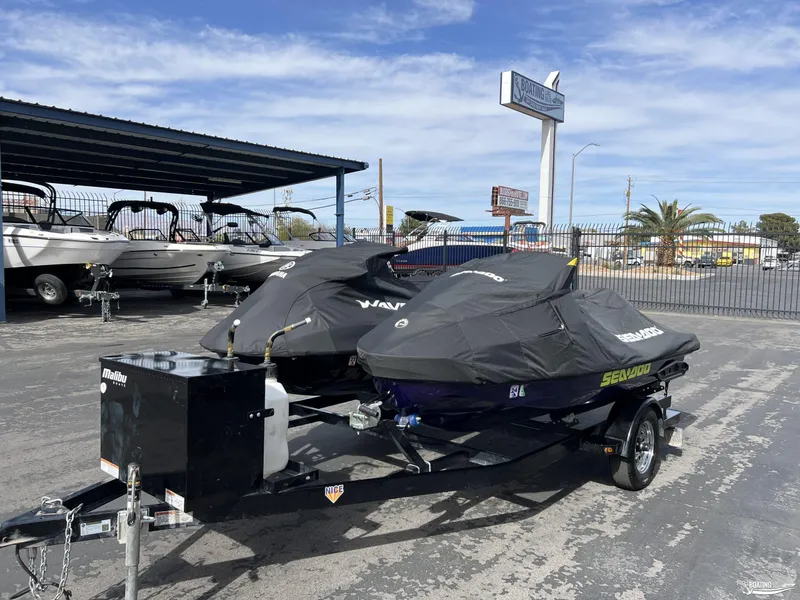 Slide: The Image of 2021 Yamaha WaveRunner GP1800R and Sea Doo RTX300 jet skis on a trailer, covered and parked. - 8