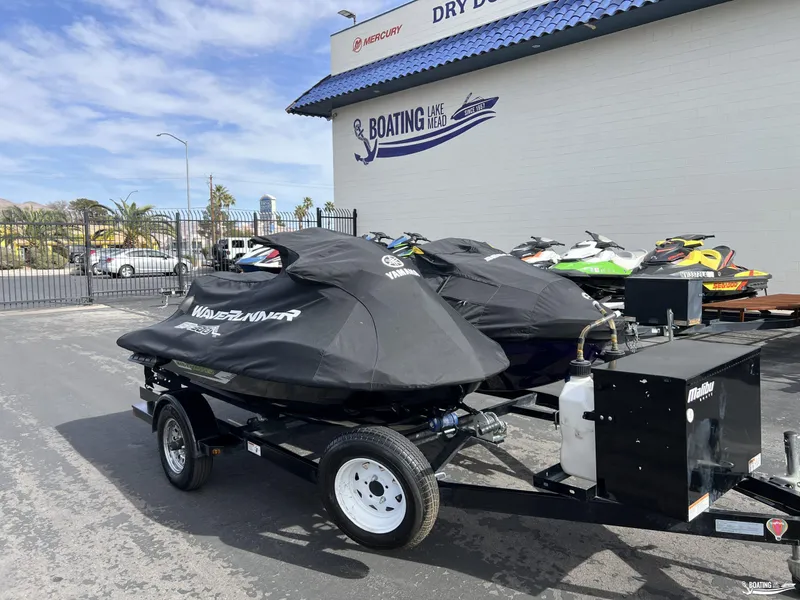Slide: The Image of 2021 Yamaha WaveRunner GP1800R jet skis covered on a trailer at a boating facility. - 9