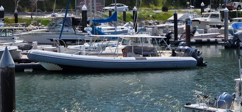 The Image of 1996 Eduardono RIB boat docked in a marina, surrounded by other vessels. - 0