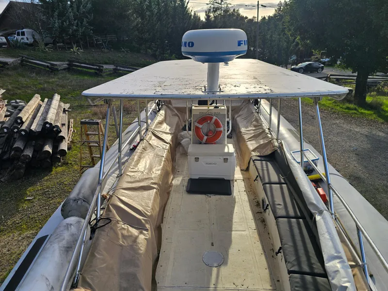 Slide: The Image of 1996 Eduardono RIB boat with canopy and radar, docked outdoors. - 10
