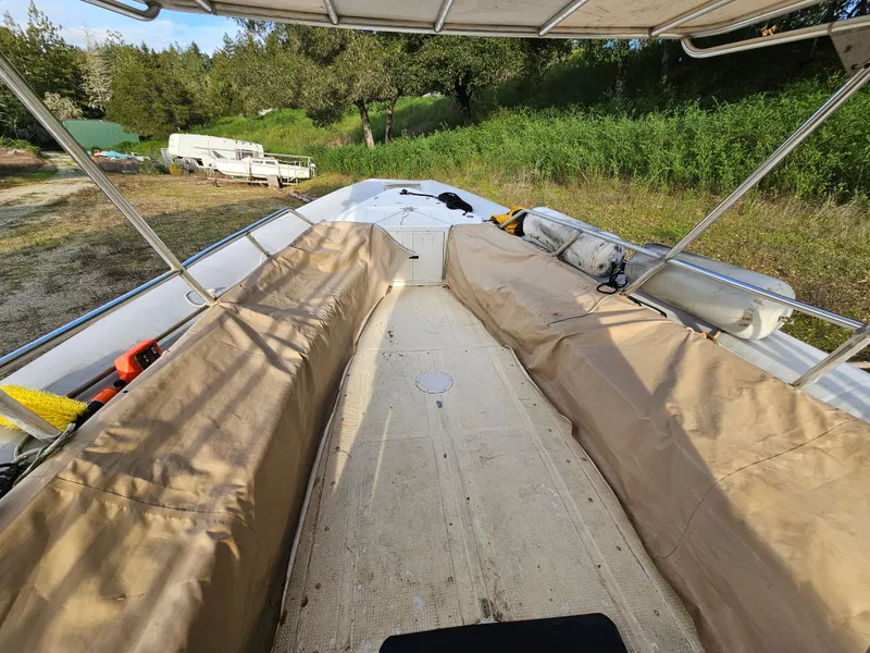 Slide: The Image of 1996 Eduardono RIB boat with covered seating, parked on grassy terrain. - 13