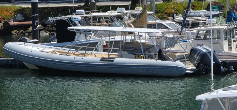 Slide: The Image of 1996 Eduardono RIB boat docked in a marina, surrounded by other vessels. - 3