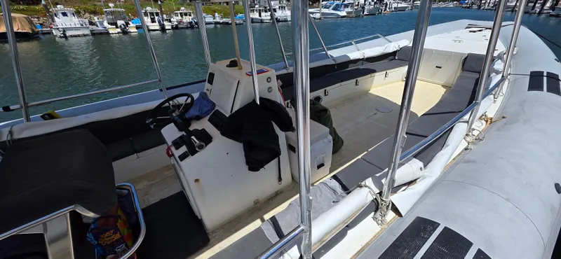 Slide: The Image of 1996 Eduardono RIB boat interior with steering console, docked at marina. - 4