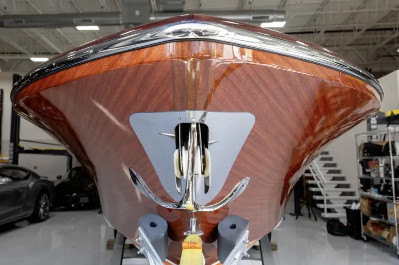 Slide: The Image of 2025 Comitti Venezia V28 boat with sleek wooden finish in a showroom. - 1
