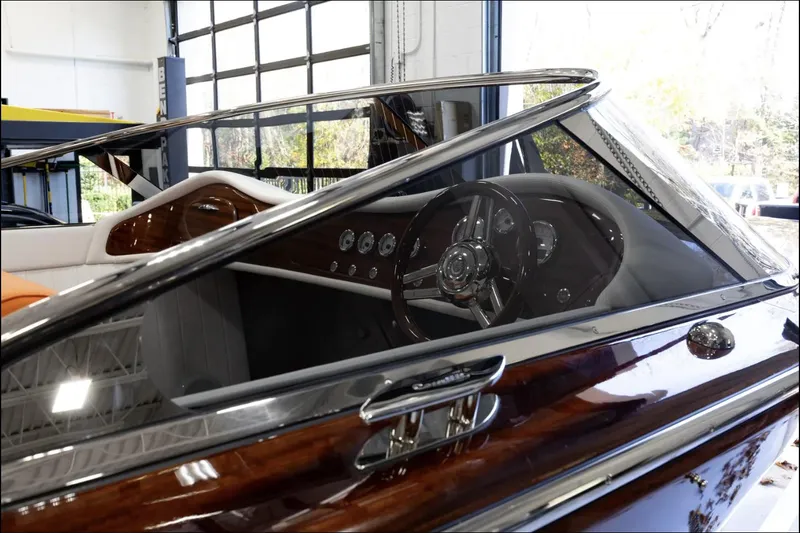 Slide: The Image of 2025 Comitti Venezia V28 luxury boat interior with polished wood and sleek dashboard design. - 4