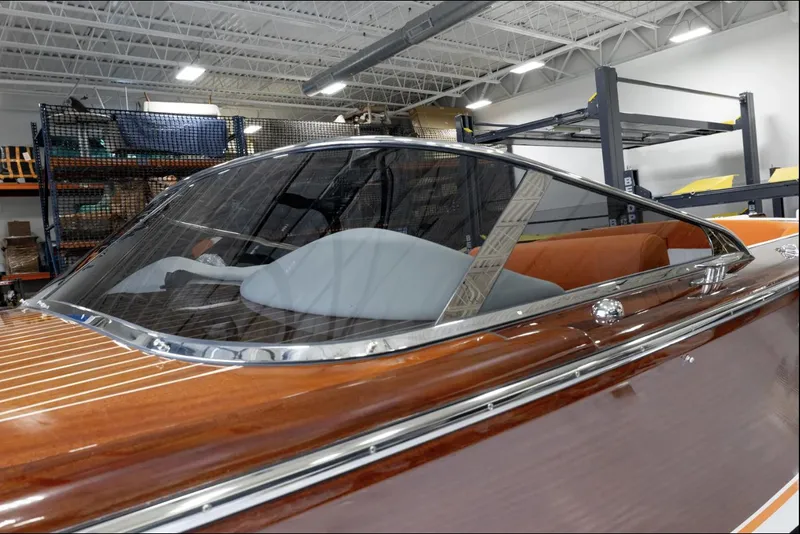 Slide: The Image of 2025 Comitti Venezia V28 luxury boat with sleek wooden finish in a showroom. - 5