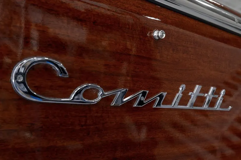 Slide: The Image of Comitti Venezia V28 2025 logo on polished wooden surface. - 6