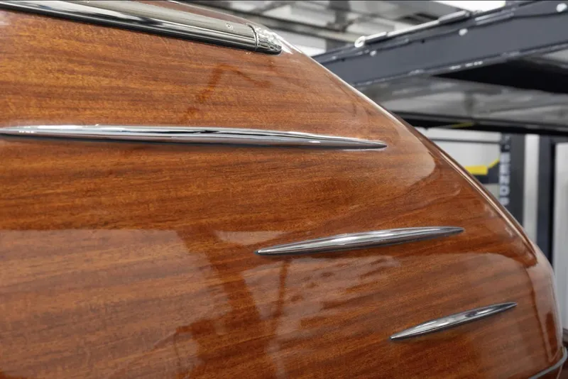 Slide: The Image of 2025 Comitti Venezia V28 wooden hull with sleek chrome accents. - 7