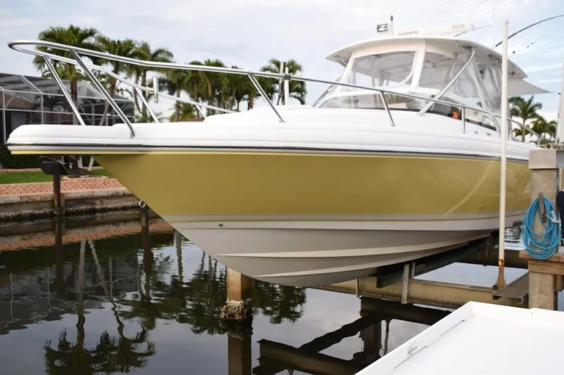 Slide: The Image of 2003 Intrepid 348 WA boat docked near palm trees, featuring a yellow hull. - 1