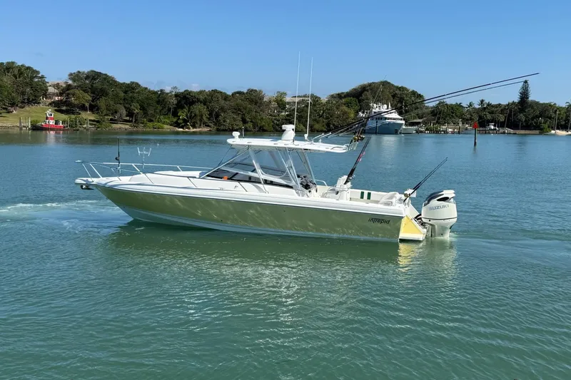 Slide: The Image of 2003 Intrepid 348 WA boat cruising on a calm lake under a clear blue sky. - 4