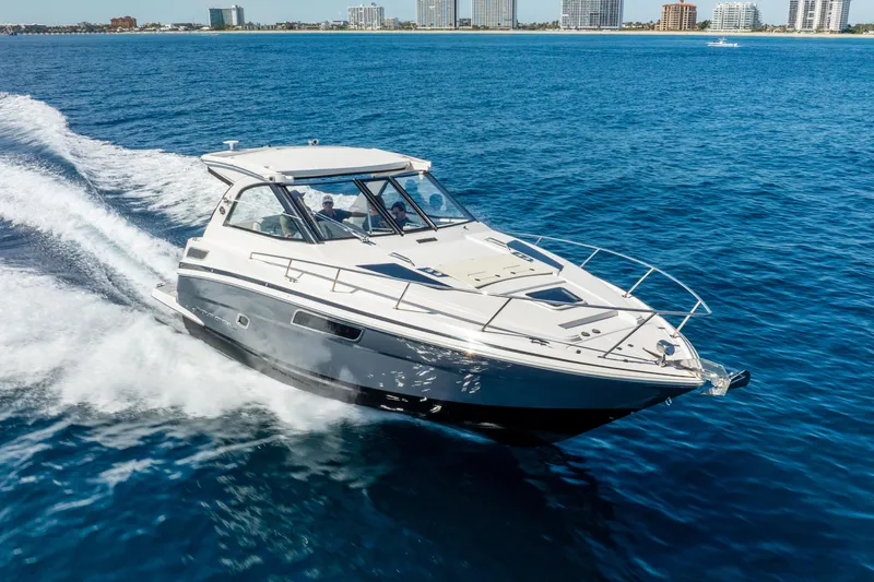 Slide: The Image of 2020 Regal 35 Sport Coupe cruising on open water near city skyline. - 12