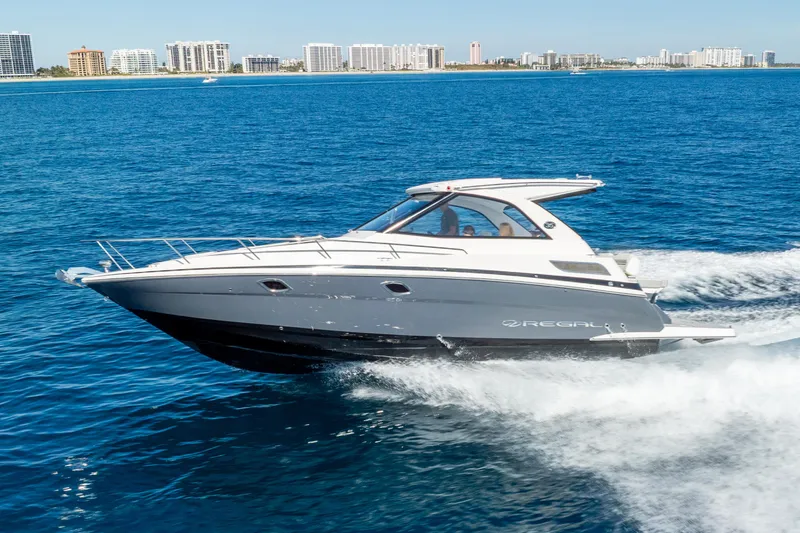 Slide: The Image of 2020 Regal 35 Sport Coupe cruising on blue ocean near city skyline. - 15