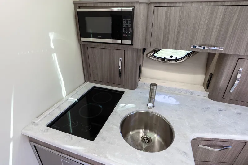 Slide: The Image of 2020 Regal 35 Sport Coupe kitchen with microwave, stovetop, and sink. - 22