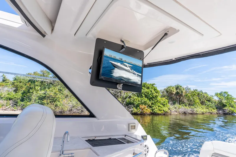 Slide: The Image of 2020 Regal 35 Sport Coupe interior with TV, scenic water view, and lush greenery. - 43