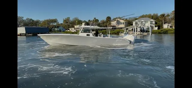Slide: The Image of 2025 Yellowfin 42 CC boat cruising in a calm waterfront setting. - 0