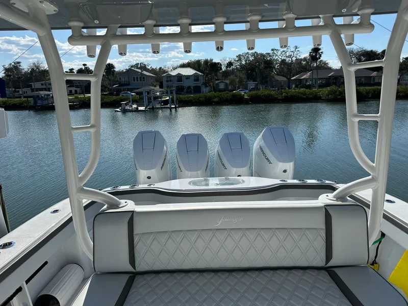 Slide: The Image of 2025 Yellowfin 42 CC boat with triple engines, docked on a serene waterfront. - 13