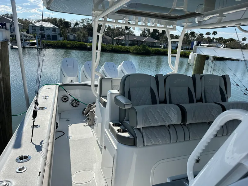 Slide: The Image of 2025 Yellowfin 42 CC boat with luxurious seating and triple engines docked by the water. - 15