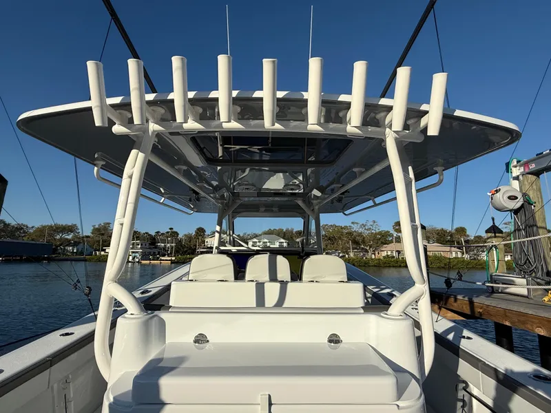 Slide: The Image of 2025 Yellowfin 42 CC boat with rod holders, docked in a serene marina setting. - 26
