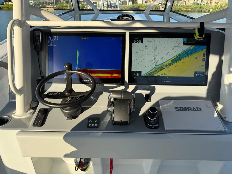 Slide: The Image of 2025 Yellowfin 42 CC boat dashboard with dual Simrad displays and steering wheel. - 30