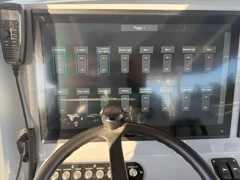 Slide: The Image of Control panel of 2025 Yellowfin 42 CC boat with touchscreen interface and steering wheel. - 33