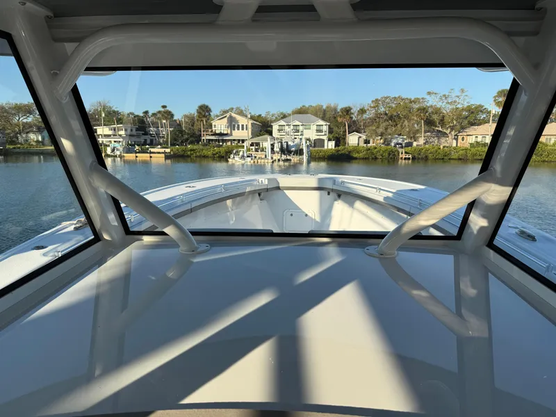 Slide: The Image of 2025 Yellowfin 42 CC boat interior view with waterfront houses in the background. - 48