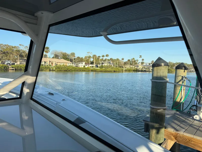 Slide: The Image of View from 2025 Yellowfin 42 CC boat window overlooking serene waterfront and dock. - 49
