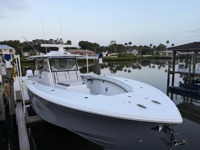 Slide: The Image of 2025 Yellowfin 42 CC boat docked in a serene marina setting. - 5