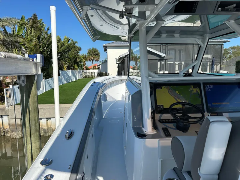 Slide: The Image of 2025 Yellowfin 42 CC boat with modern cockpit and navigation system, docked by waterfront. - 50