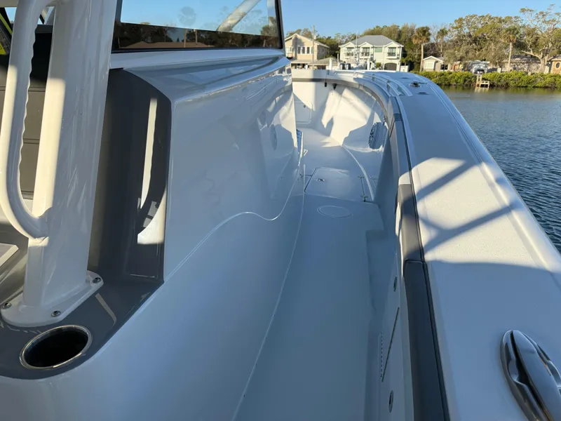 Slide: The Image of 2025 Yellowfin 42 CC boat deck, sleek design, docked by waterfront homes. - 52