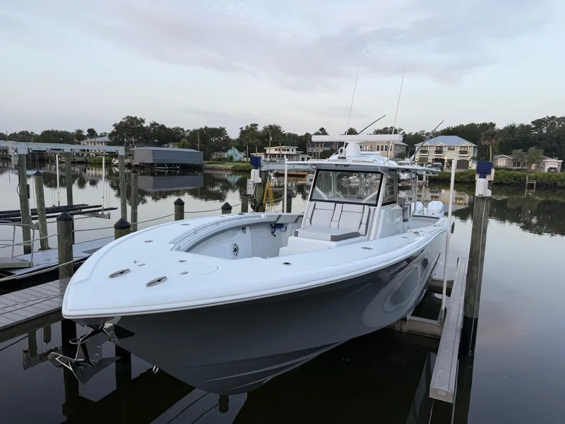 Slide: The Image of 2025 Yellowfin 42 CC boat docked in a serene marina setting. - 6