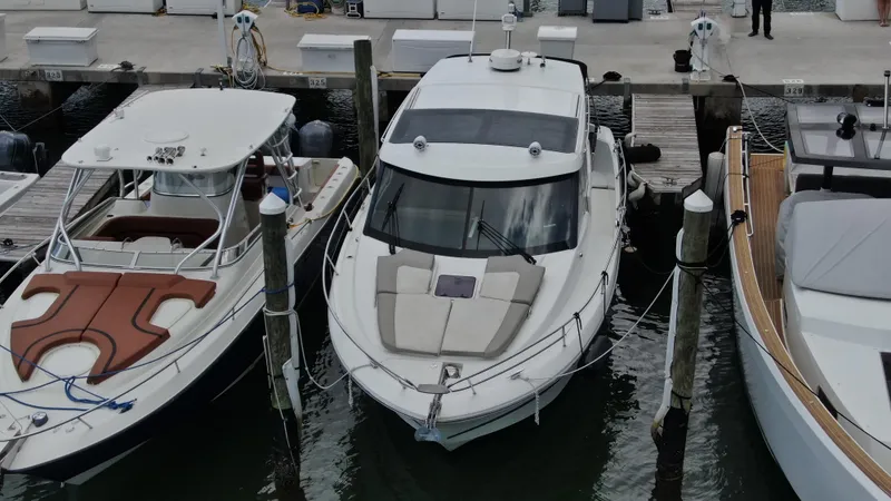 Slide: The Image of 2017 Jeanneau NC 11 docked between boats at a marina. - 1