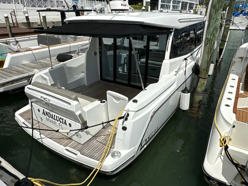 Slide: The Image of 2017 Jeanneau NC 11 yacht docked, featuring sleek design and spacious deck area. - 19