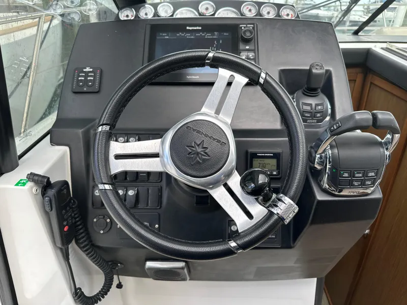 Slide: The Image of Steering wheel and controls of a 2017 Jeanneau NC 11 boat cockpit. - 22