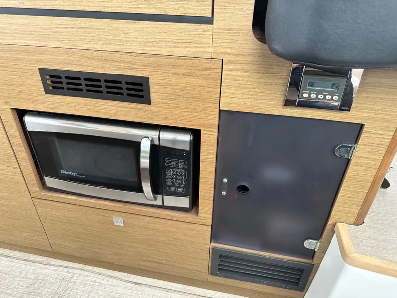 Slide: The Image of Microwave and control panel in 2017 Jeanneau NC 11 boat interior. - 24
