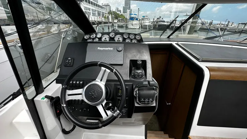 Slide: The Image of 2017 Jeanneau NC 11 helm with steering wheel and navigation controls. - 3