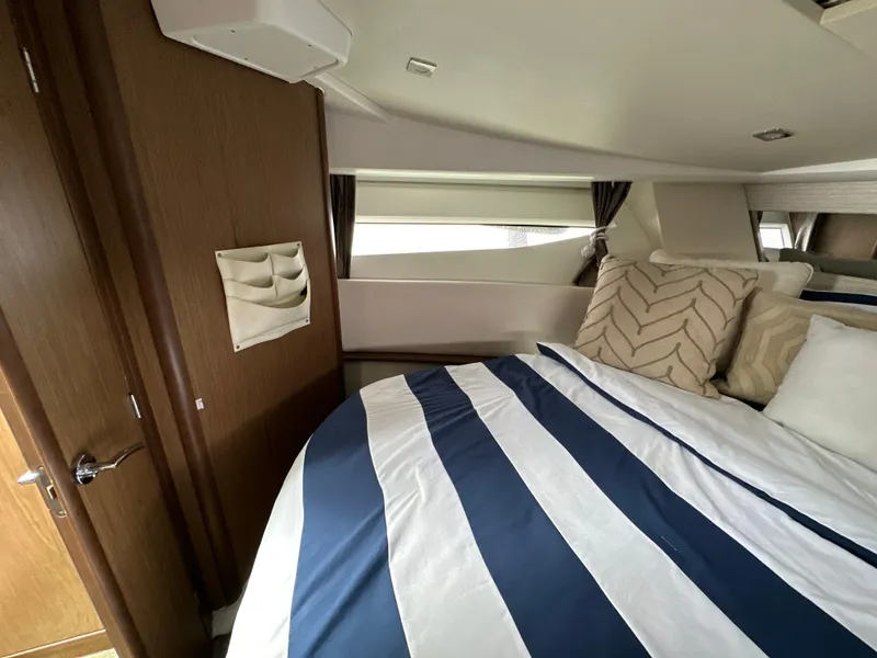 Slide: The Image of Interior cabin of 2017 Jeanneau NC 11 with striped bedding and decorative pillows. - 39