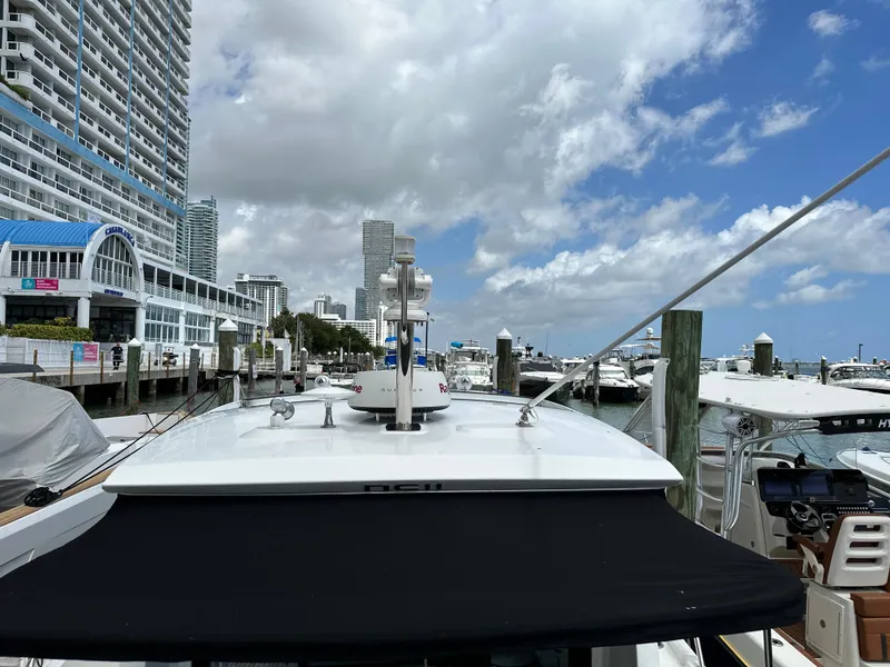 Slide: The Image of 2017 Jeanneau NC 11 docked at a marina with cityscape background. - 42