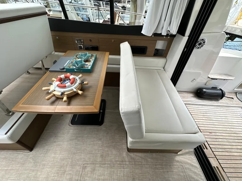 Slide: The Image of Interior of 2017 Jeanneau NC 11 yacht with elegant seating and wooden table. - 47