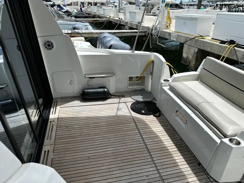 Slide: The Image of 2017 Jeanneau NC 11 boat deck with seating, docked at marina. - 9