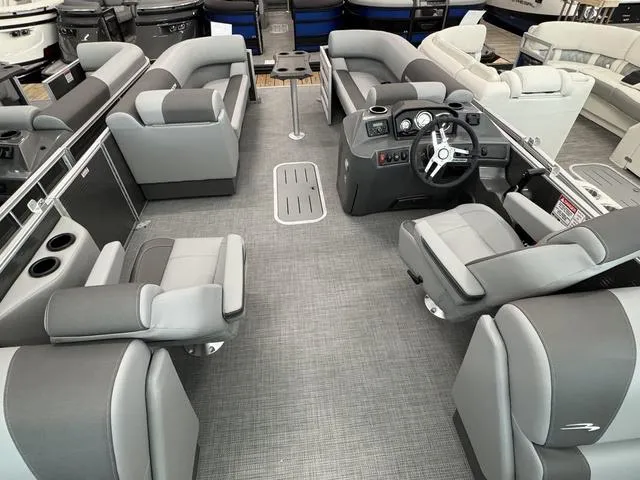 Slide: The Image of 2025 Bennington S Quad Bench 22 SSR pontoon boat interior with gray seating and steering console. - 6