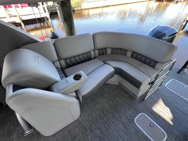 Slide: The Image of Luxurious seating on 2021 Bennington QX 27 pontoon boat, featuring plush upholstery and cup holder. - 19